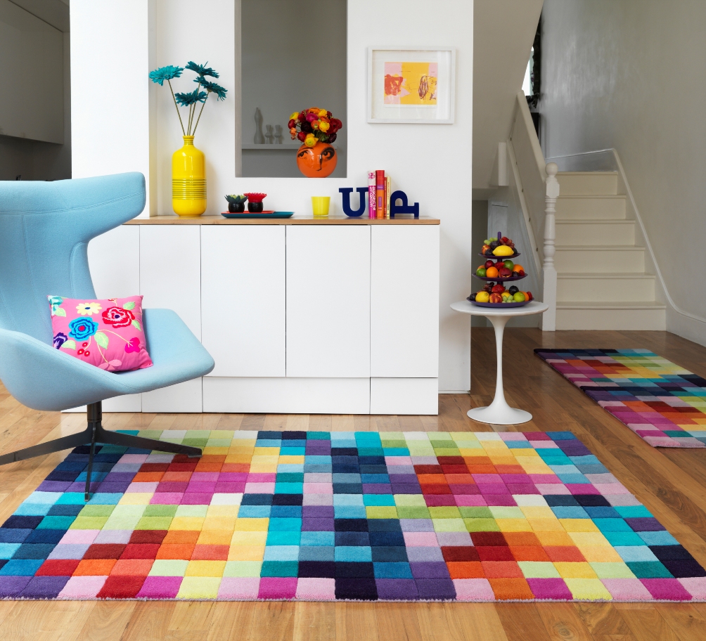 Et teppe med flerfargede firkanter i stuen