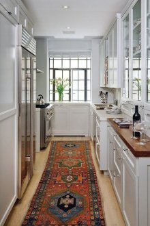Στενή φωτεινή κουζίνα με όμορφο χαλί