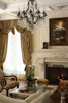 Πολυέλαιος από σφυρήλατο σίδερο στο σαλόνι με τζάκι