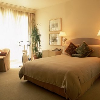 Λαμπτήρες τοίχου και επιτραπέζιου φωτισμού σε μια μπεζ-καφέ κρεβατοκάμαρα