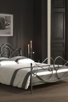 Κρεβάτι από σφυρήλατο σίδερο σε ένα ασπρόμαυρο υπνοδωμάτιο