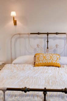 Μπεζ-καφέ κρεβάτι από σφυρήλατο σίδερο στο υπνοδωμάτιο