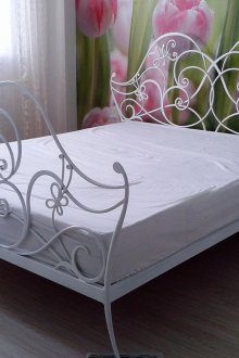 Υπνοδωμάτιο εσωτερικό με λευκό κρεβάτι σφυρήλατο σίδερο