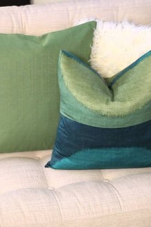 Πράσινα μαξιλάρια σε έναν φωτεινό καναπέ