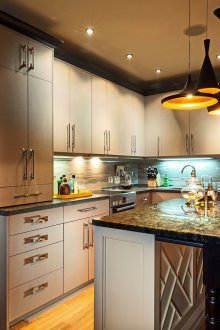 Διαφορετικοί πολυέλαιοι και προβολείς στην κουζίνα με μπαρ για πρωινό