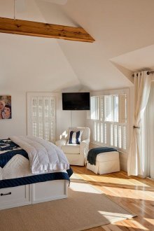 Λευκό κρεβάτι με συρτάρια σε ευρύχωρο υπνοδωμάτιο