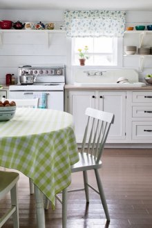 Λευκοί ξύλινοι τοίχοι και καφέ δάπεδο σε μια εξοχική κουζίνα