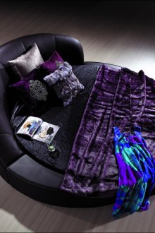 Στρογγυλό μωβ δερμάτινο κρεβάτι στο υπνοδωμάτιο