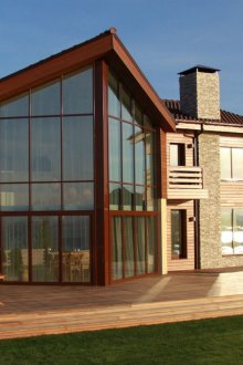 Το τζάμι της πρόσοψης ενός άνετου διώροφου εξοχικού σπιτιού