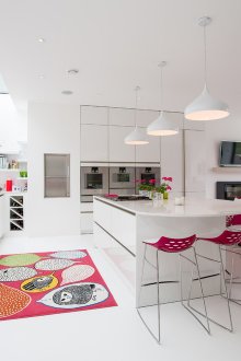 Ροζ πινελιές στο λευκό εσωτερικό του σαλόνι-κουζίνα