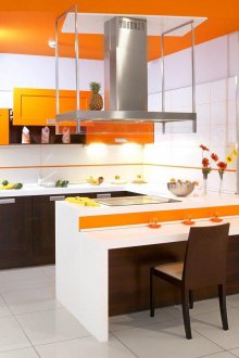 Colori arancioni, bianchi e marroni all'interno della cucina con una penisola