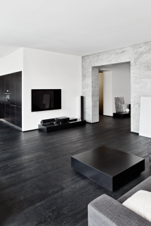 Λευκή οροφή σε ένα μαύρο και άσπρο σαλόνι-κουζίνα