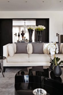 Intérieur de salon noir et blanc avec des accents gris et beiges.