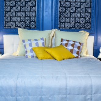 Κίτρινα μαξιλάρια και μπλε κάλυμμα στο υπνοδωμάτιο