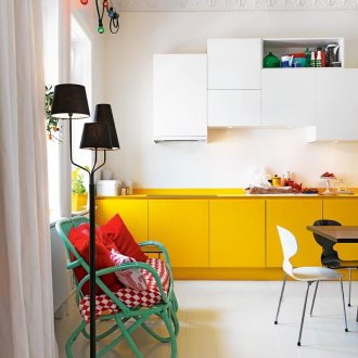 Πράσινος καναπές σε μια λευκή και κίτρινη κουζίνα