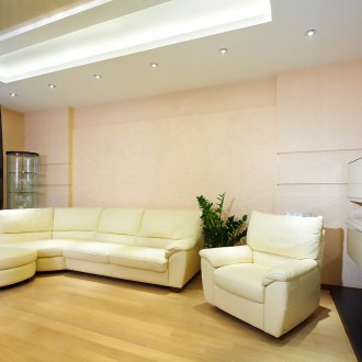 Μπεζ καναπέ και πολυθρόνα στο στυλ του μινιμαλισμού.