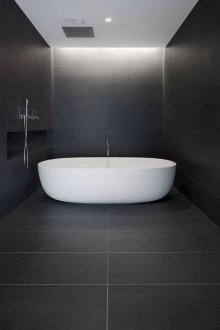 Λευκή μπανιέρα και μαύροι τοίχοι