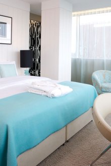 Μπεζ κρεβάτι και πολυθρόνα στην κρεβατοκάμαρα