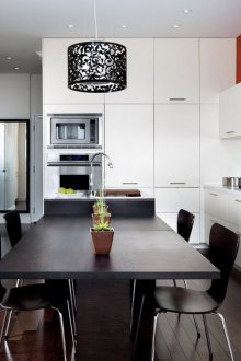 Πορτοκαλί τοίχο σε μια μαύρη και άσπρη κουζίνα