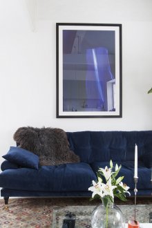 Μπλε καναπές και εικόνα σε ένα λευκό καθιστικό