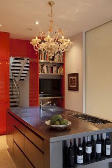 Κλασικός πολυέλαιος σε πορτοκαλί κουζίνα με νησί