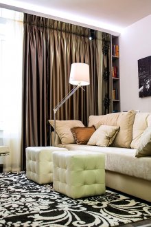 Καφέ κουρτίνες και μια ζώνη καθρέφτη σε ένα ασπρόμαυρο σαλόνι