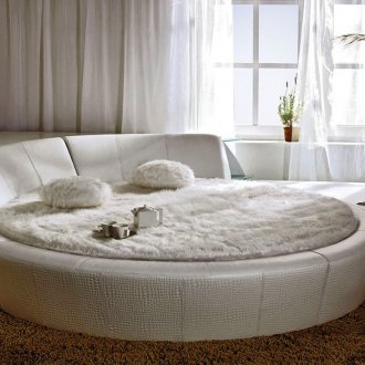 Λευκό στρογγυλό κρεβάτι με ράφια στο υπνοδωμάτιο