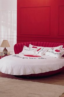 Κόκκινο και λευκό επιβλητικό στρογγυλό κρεβάτι στο υπνοδωμάτιο