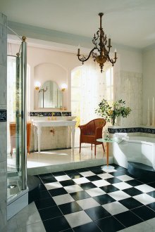 Χρυσά υδραυλικά σε μια ασπρόμαυρη μπανιέρα