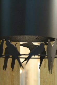 Araña de metal negro con pájaros