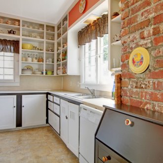 Φωτεινή κουζίνα με τοίχο από τούβλα