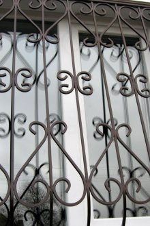 Μαύρη μάσκα παραθύρων με στοιχεία από σφυρήλατο σίδερο.