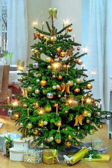 Διακόσμηση ενός τεχνητού χριστουγεννιάτικου δέντρου με χρυσά παιχνίδια