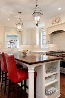 Κόκκινες καρέκλες σε μια καφετιά και άσπρη κουζίνα