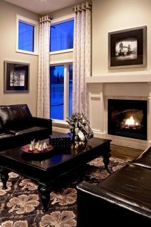 Δερμάτινοι μαύροι καναπέδες στο σαλόνι με τζάκι