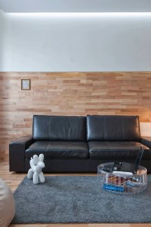 Μαύρος δερμάτινος καναπές σε καφέ και λευκό εσωτερικό