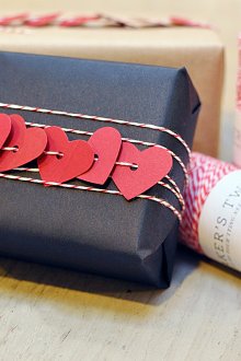 Διακόσμηση δώρων με σκοτεινό χαρτί και σχοινί με καρδιές.