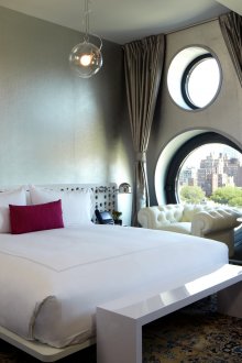 Γκρίζο και λευκό δωμάτιο με στρογγυλά παράθυρα.