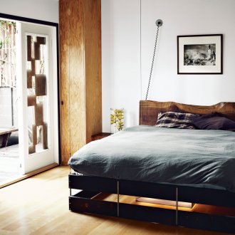 Κρεμαστό μαύρο ξύλινο κρεβάτι στο υπνοδωμάτιο