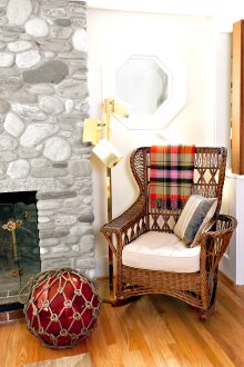 Όμορφη λικνίστικη καρέκλα στο καθιστικό με τζάκι