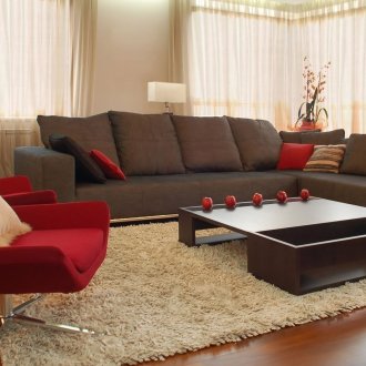 Κόκκινη πολυθρόνα και μαξιλάρια στο σαλόνι