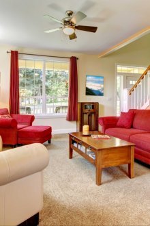 Κόκκινο καναπέ, πολυθρόνα και κουρτίνες στο σαλόνι