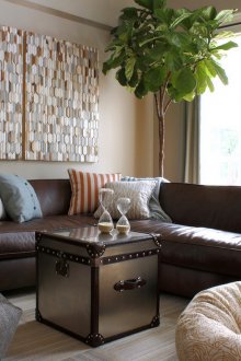 Καφέ καναπέ στο σαλόνι με γκρι κουρτίνες