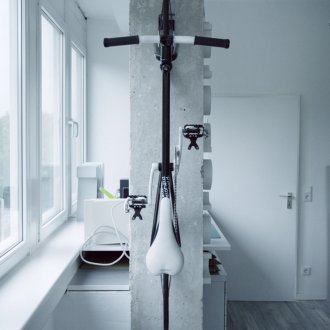 Κρατώντας το ποδήλατο στον τοίχο του διαμερίσματος