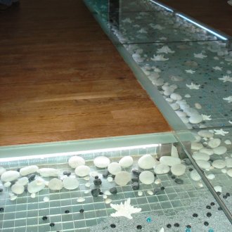 Διακοσμητικές πέτρες κάτω από γυάλινο πάτωμα