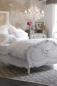 Υπνοδωμάτιο με ασυνήθιστο πολυέλαιο και ένα λευκό σοφίτα στο στυλ του shabby chic