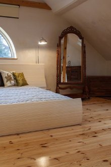 Δωμάτιο με σοφίτα με ελαφρύ ξύλινο πάτωμα και ημικυκλικό παράθυρο