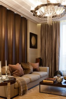 Καφέ-μπεζ σχεδίαση καθιστικού με κρεμαστό ογκομετρικό πολυέλαιο