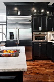 Κουζίνα με μαύρη πρόσοψη και ξύλινο παρκέ