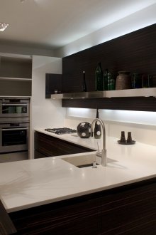 Σκούρη κουζίνα με πάγκο από ελαφρύ πέτρινο δάπεδο